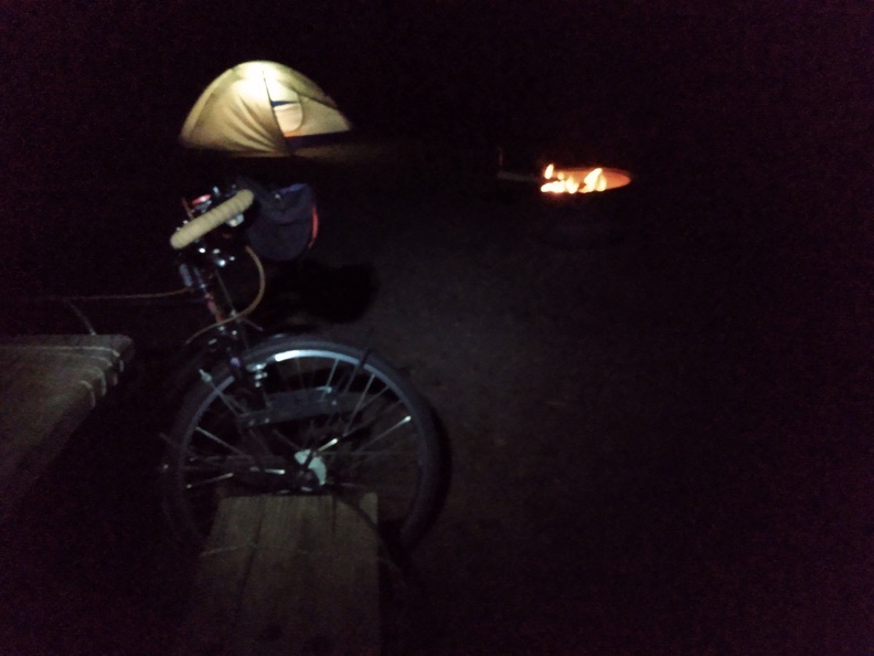 campfire, bike and tent at night